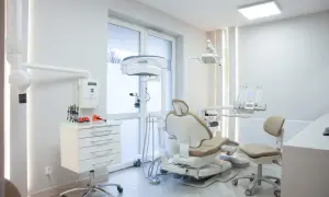 Nowoczesny gabinet stomatologiczny z fotelem dentystycznym i sprzętem.