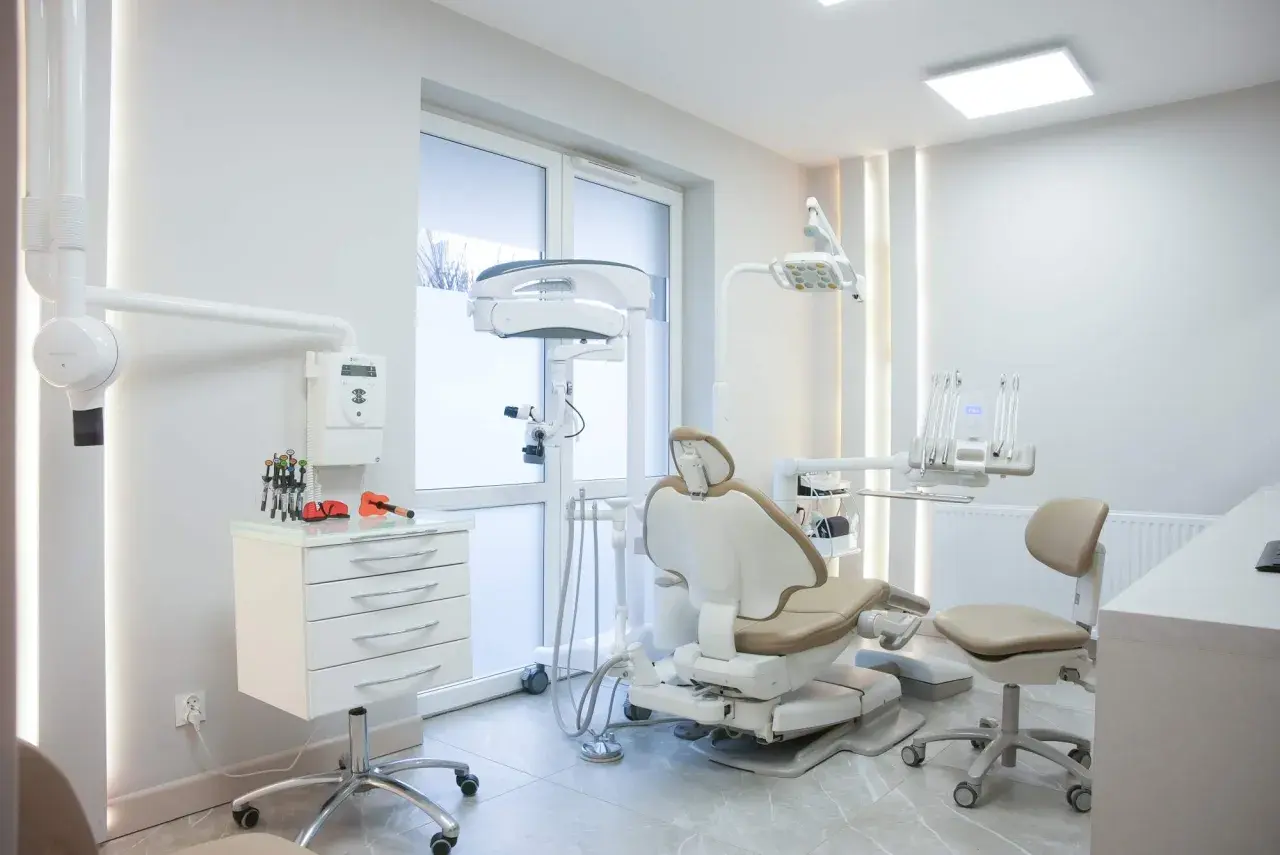 Nowoczesny gabinet stomatologiczny z fotelem dentystycznym i sprzętem.